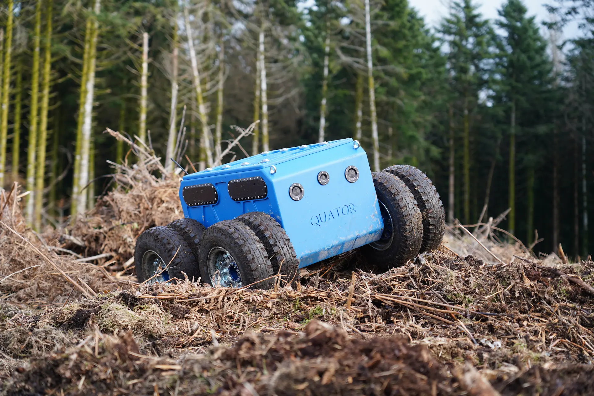 Le robot Quator de Sfynx Industry évolue sur un terrain forestier recouvert de feuilles et de branches. Grâce à sa configuration à double roue motrice et sa conception robuste, ce robot tout-terrain assure une excellente stabilité et une adhérence optimale dans les environnements naturels complexes.